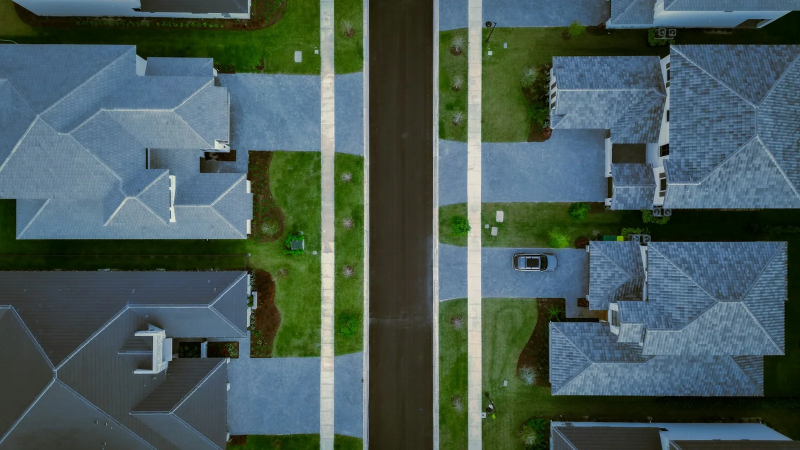 Overhead view of residential roofs, yards and a neighborhood street